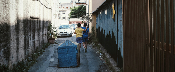 Due bambini camminano abbracciati per strada