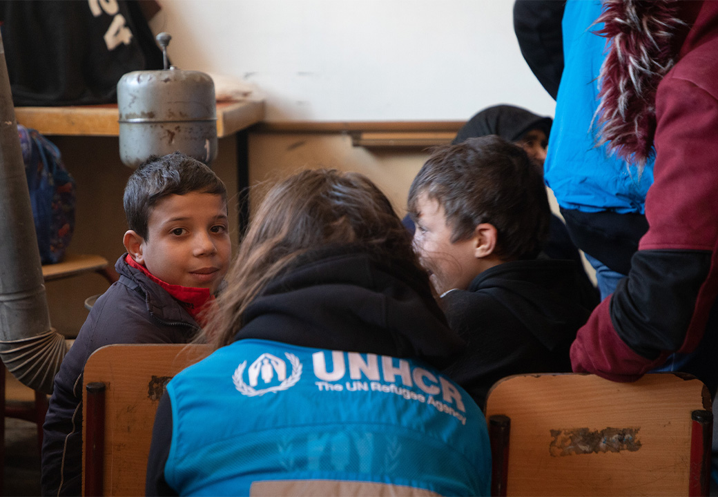 Bambino con un'operatrice volontaria di UNHCR