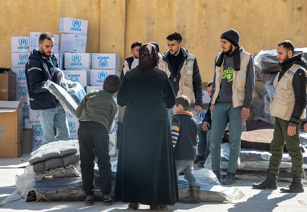 Operatori UNHCR offrono supporto a una donna e dei bambini siriani