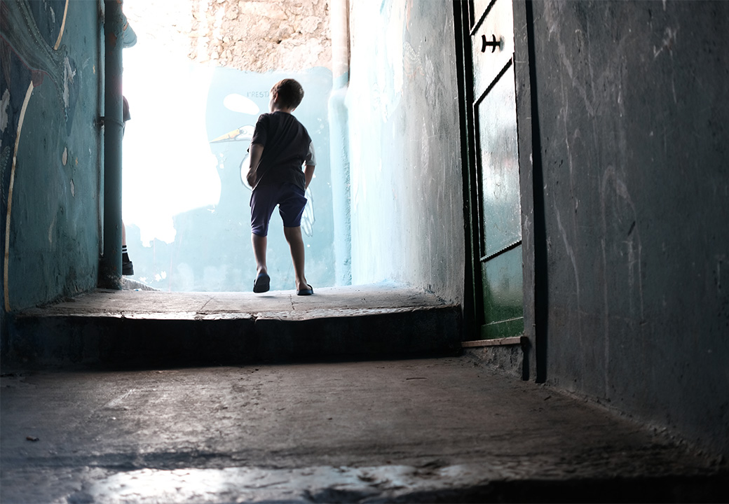 Un bambino corre in un vicolo stretto della città