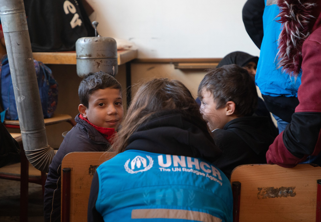 Dei bambini parlano con dei volontari di UNHCR