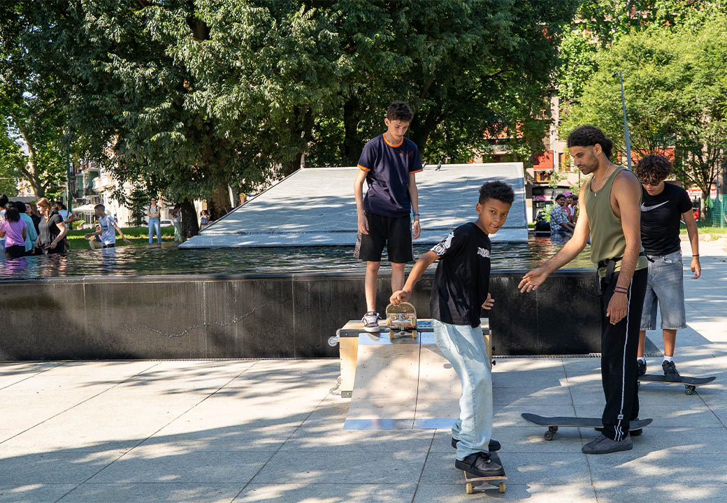 Dei ragazzi imparano ad andare sullo skateboard con l'aiuto di un istruttore
