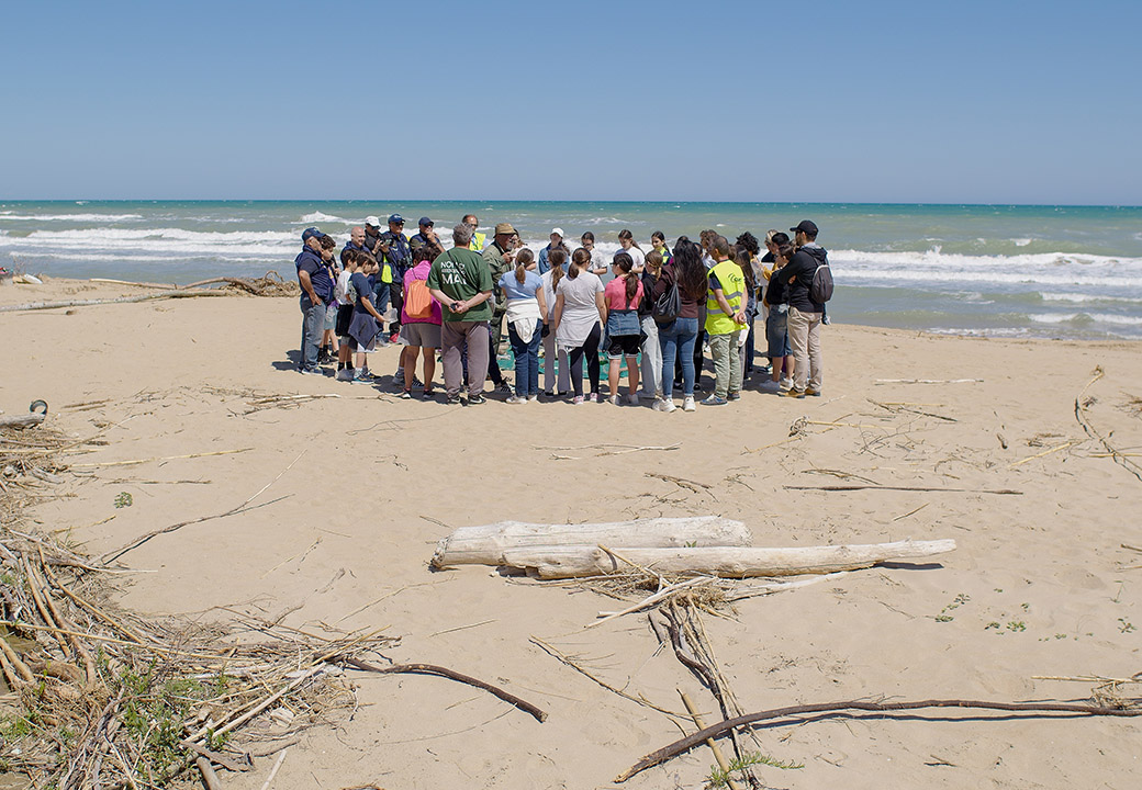 Un gruppo di ragazzi radunato in cerchio in una spiaggia